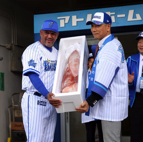 沖縄の名産品のソデイカを受け取るDeNAラミレス監督（左）（撮影・大野祥一）