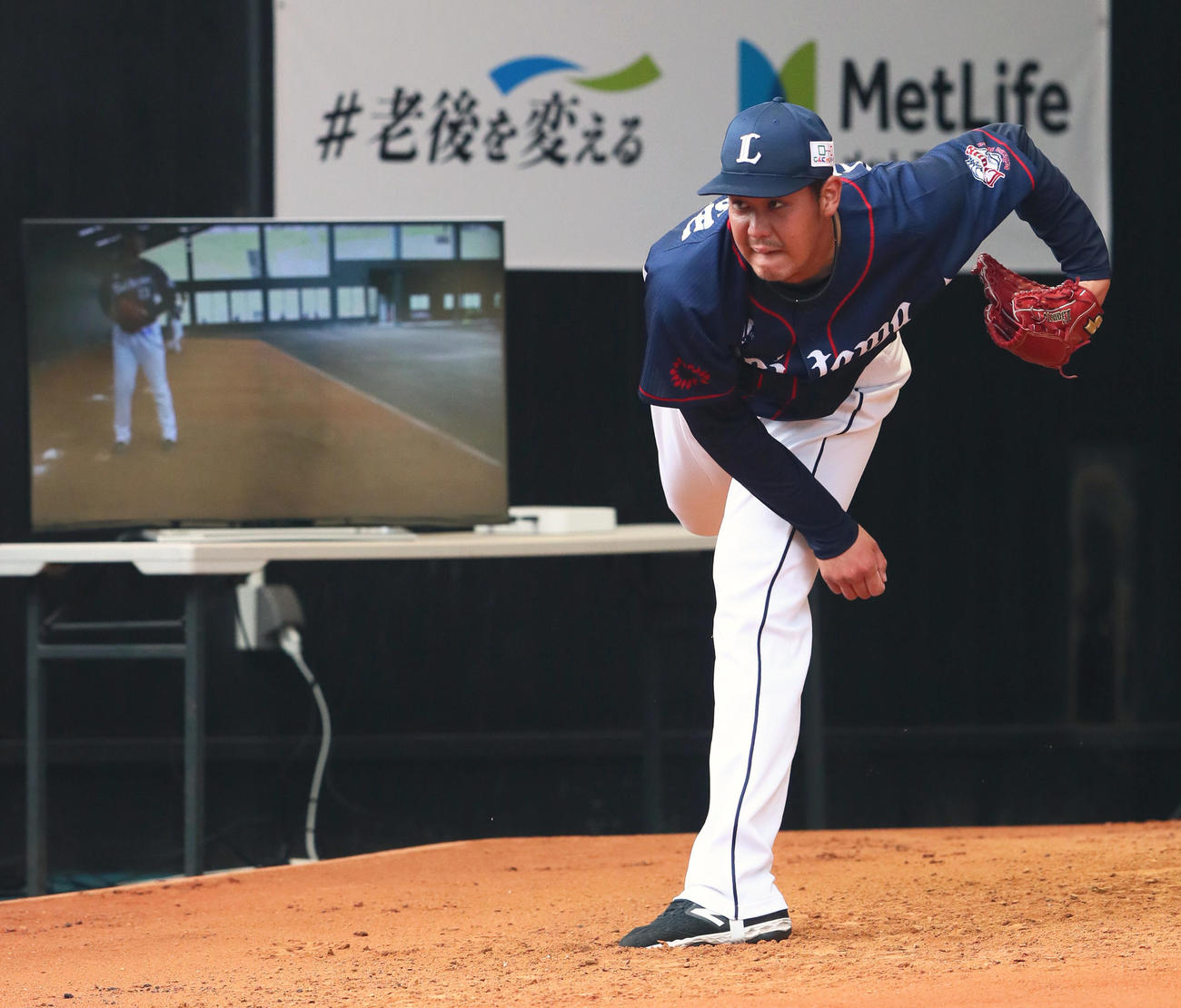 打撃投手を終えブルペンで調整する西武高橋光。左には投球の映像が時間差で映るモニターが置かれている（撮影・足立雅史）