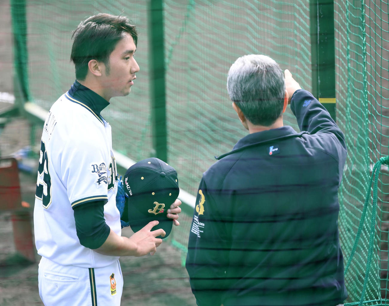 打撃投手を務めた田嶋（左）は山田臨時コーチのアドバイスを聞く（撮影・前岡正明）