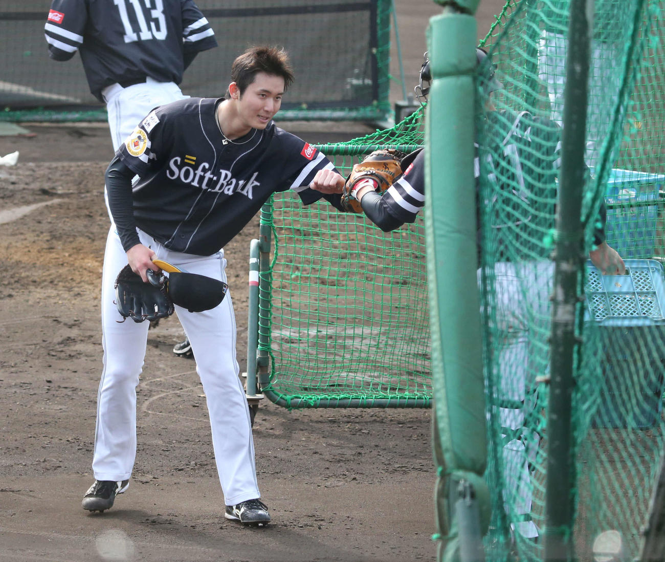フリー打撃での登板を終えた高橋純は、栗原とグータッチ（撮影・菊川光一）
