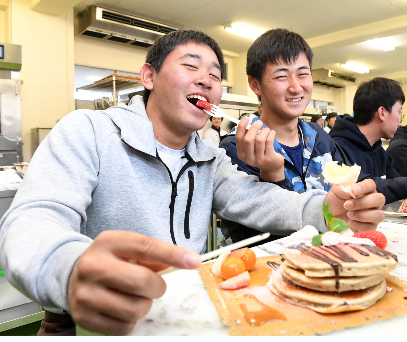 九州パンケーキ作りに挑戦したオリックスの新人選手。宮城（左）は紅林から食べさせてもらう（撮影・前岡正明）