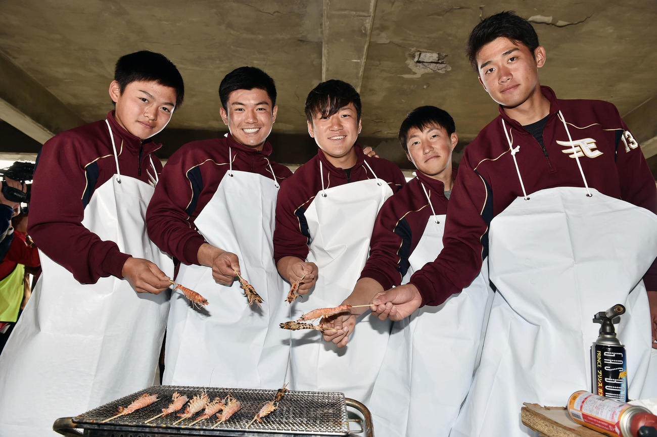 休日に車エビの養殖場を訪れた楽天新人選手は焼きたてのエビを手に記念撮影する。左から水上、津留崎、福森、小深田、小峯（撮影・滝沢徹郎）