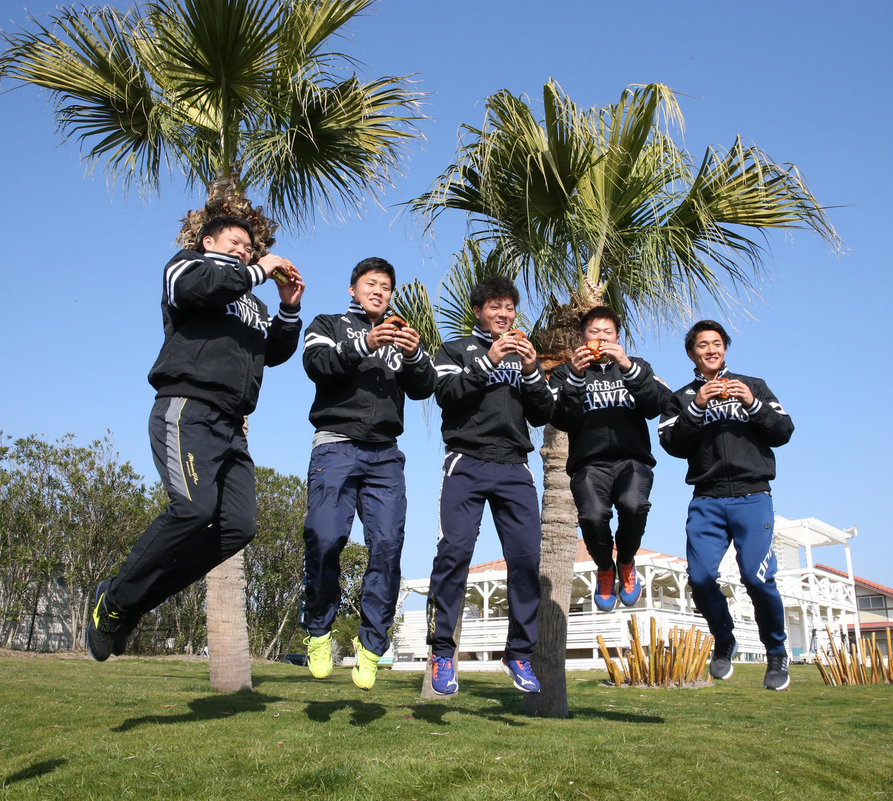 新人選手の1日体験で、手作りハンバーガーを手にジャンプする左から小林珠維、海野隆司、佐藤直樹、津森宥紀、柳町達　（撮影・菊川光一）
