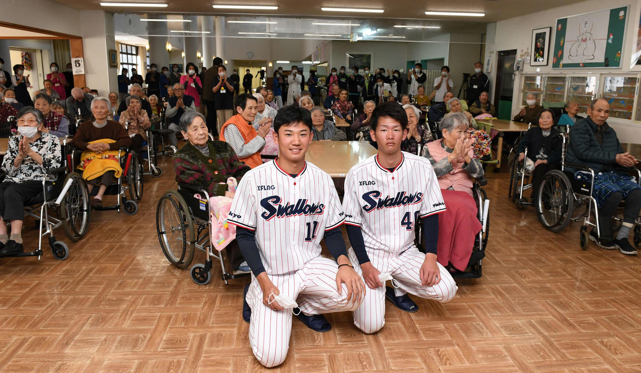介護老人保健施設「並木の里」を慰問し、入居者たちとの記念写真に納まるヤクルト奥川（中央左）と市川（同右）（撮影・鈴木みどり）