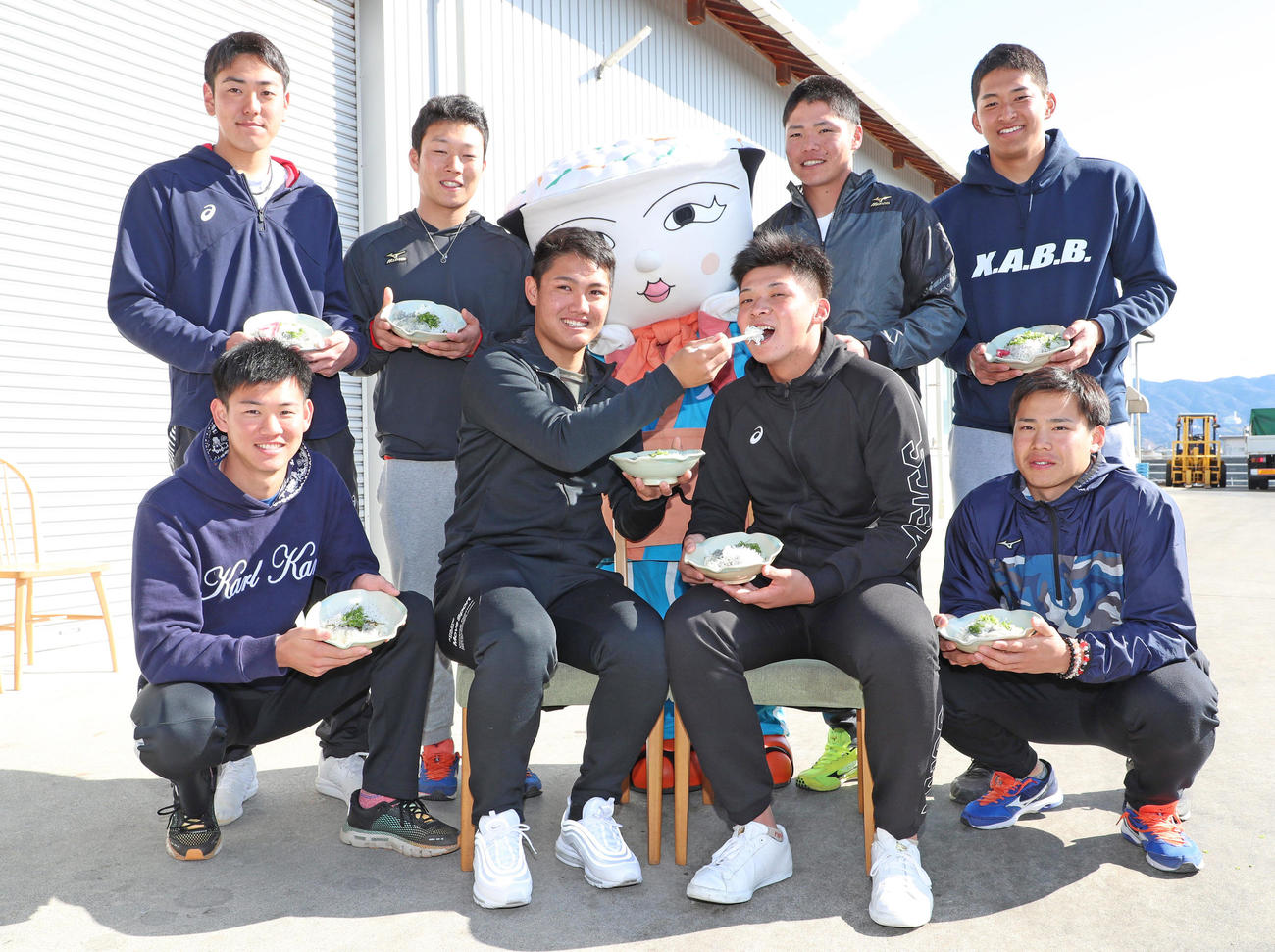 「安芸水産」でちりめん加工場見学を行いしらす丼を手に笑顔をみせる西純矢ら新人選手たち、前列左から及川雅貴、西純矢、井上広大、遠藤成、後列左から小川一平、藤田健斗、小野寺暖、奥山皓太（撮影・清水貴仁）
