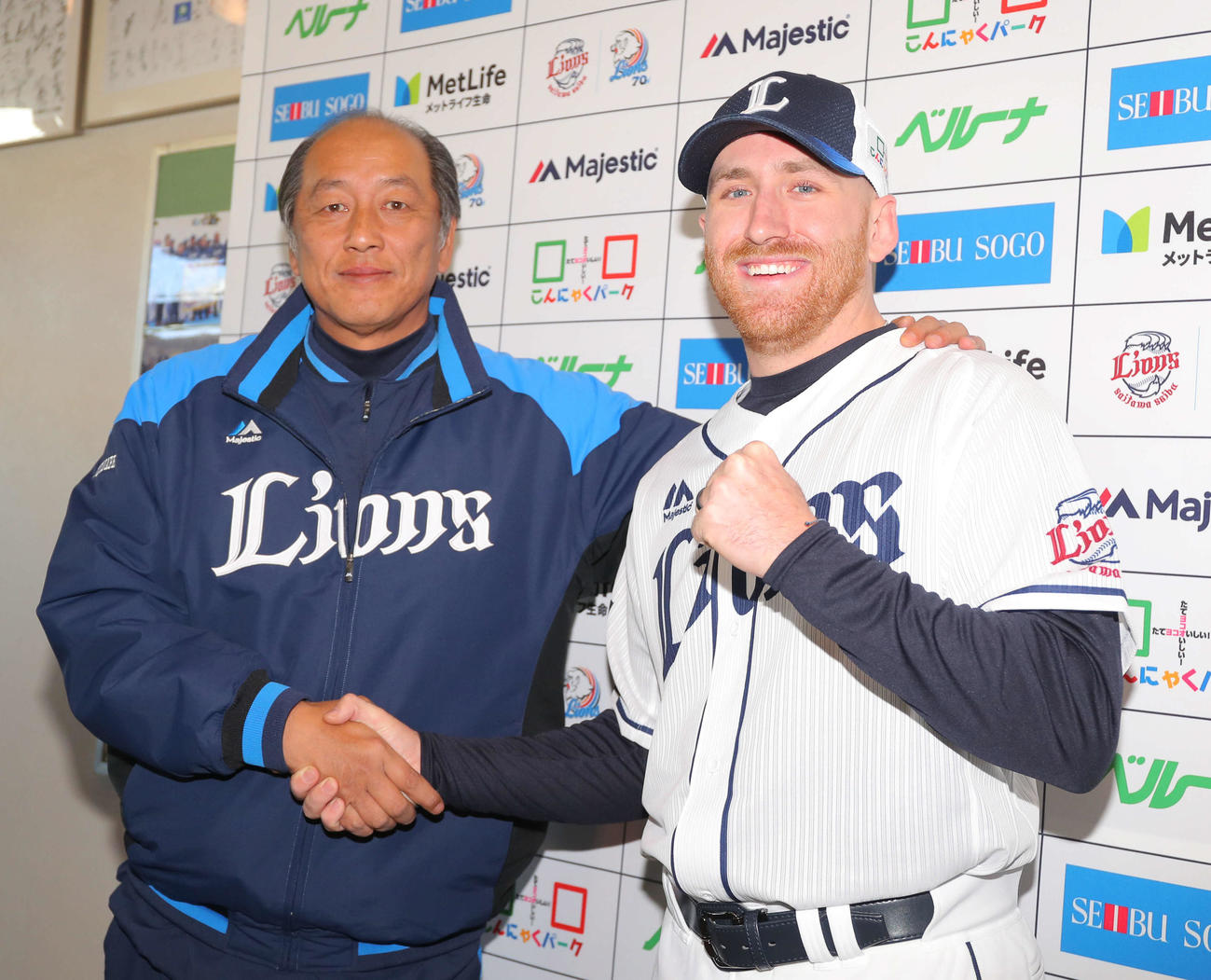 西武入団会見で渡辺GMと笑顔で握手を交わすギャレット（撮影・河田真司）