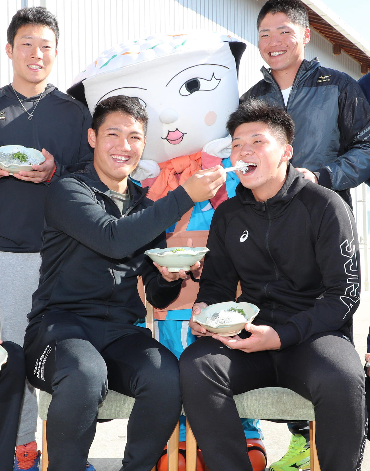 「安芸水産」でちりめん加工場見学を行い西純矢（前列左）が井上広大にしらす丼を食べさせてあげる（撮影・清水貴仁）