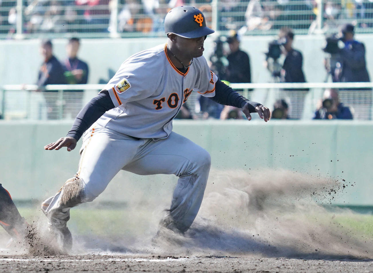 巨人宮崎キャンプ紅白戦　紅組対白組　5回表紅組1死一、三塁、三塁走者モタは岸田行倫の右犠飛で本塁に滑り込み逆転の生還。巻き上がった土煙の中立ち上がる姿は、サーファーが波を乗りこなしているよう。レギュラー獲得に向けて幾多の荒波を乗り越えてもらいたい期待の新戦力です（撮影・加藤諒）