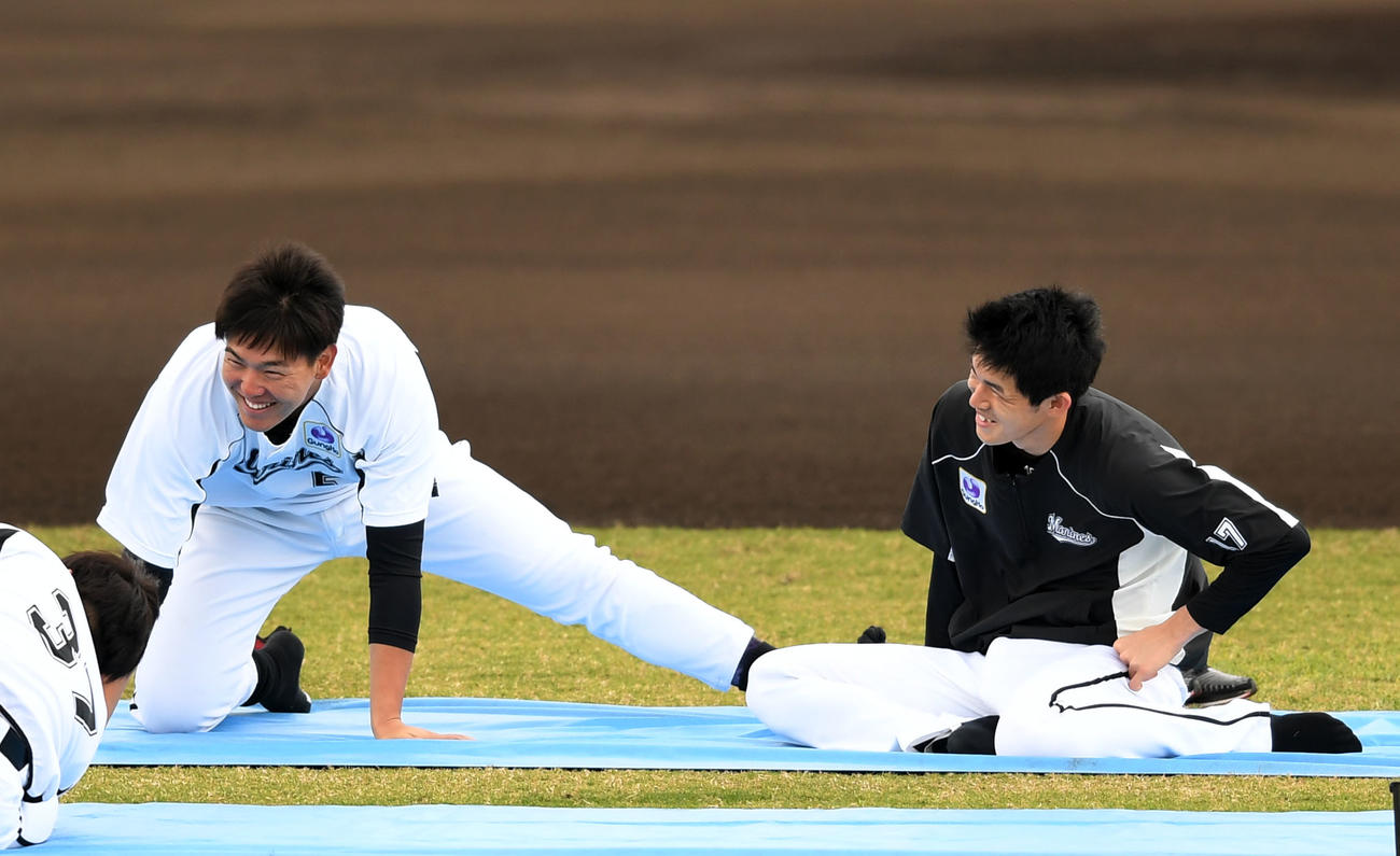 ストレッチしながら笑顔を見せるロッテ佐々木朗（右）と安田（撮影・横山健太）