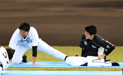 ストレッチしながら笑顔を見せるロッテ佐々木朗（右）と安田（撮影・横山健太）