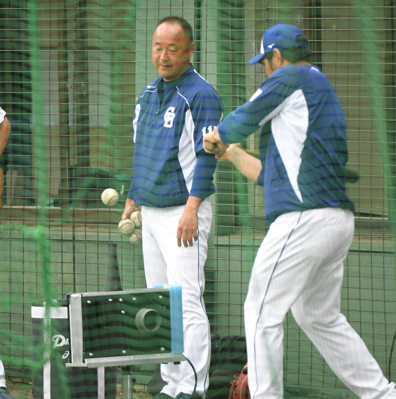 中日ドラゴンズ春季沖縄キャンプ　エアでボールを浮かせる打撃練習用マシンのテストを繰り返すスタッフ（撮影・森本幸一）
