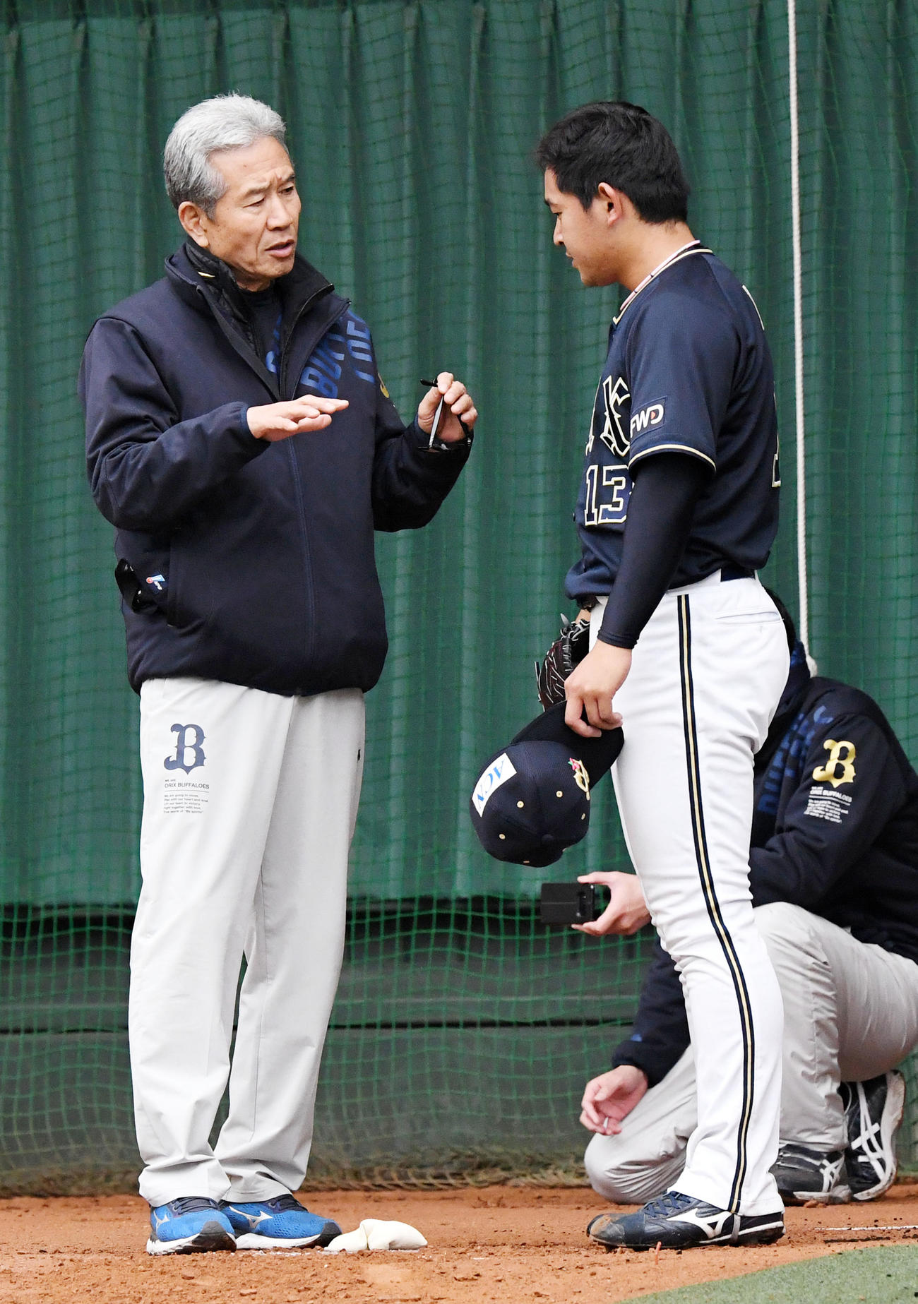 ブルペンで投球練習を行う宮城大弥（右）にアドバイスする山田久志臨時コーチ（撮影・前岡正明）