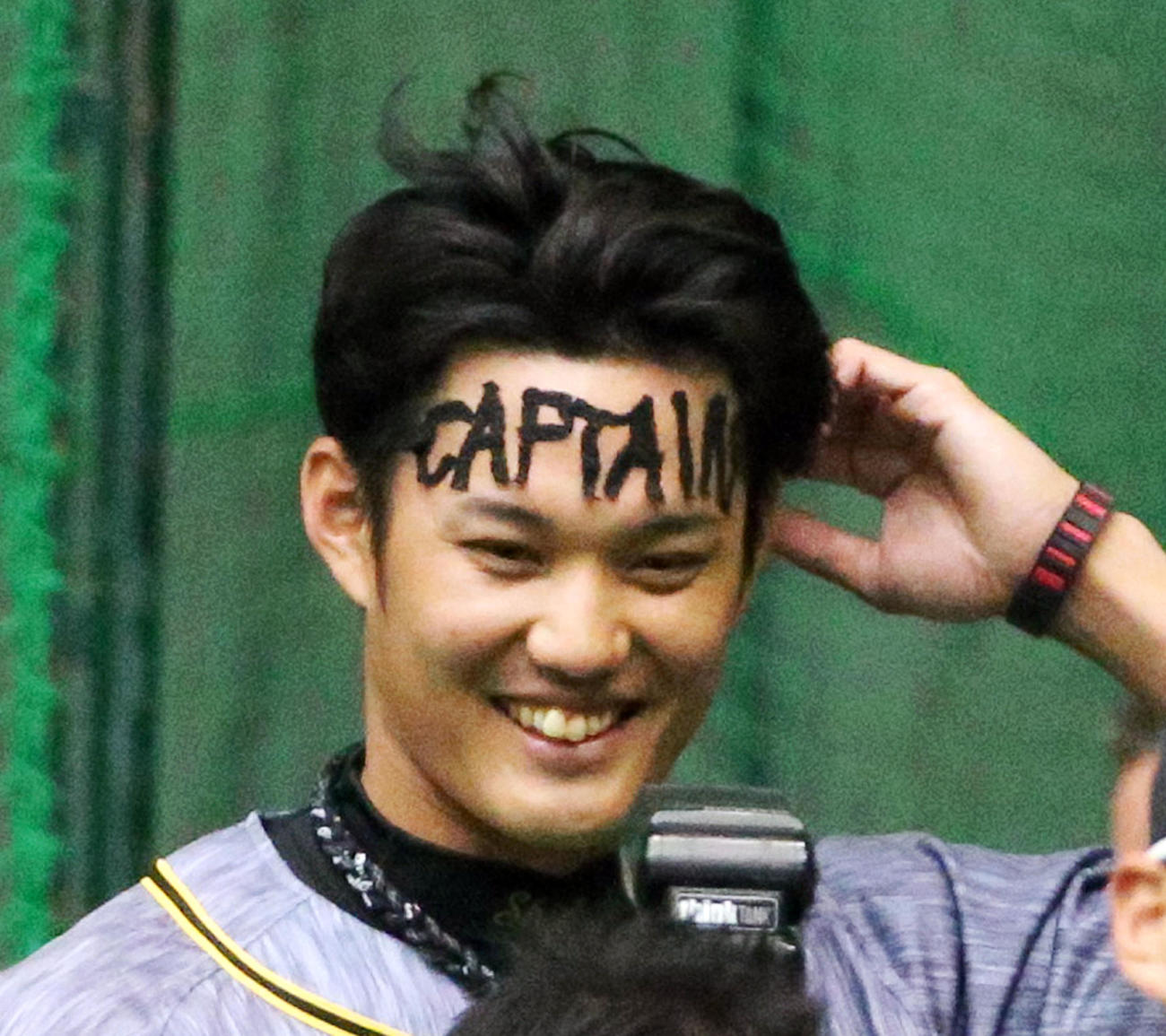 1日キャプテンの藤浪は額に「CAPTAIN」テープを張って披露する（撮影・上山淳一）