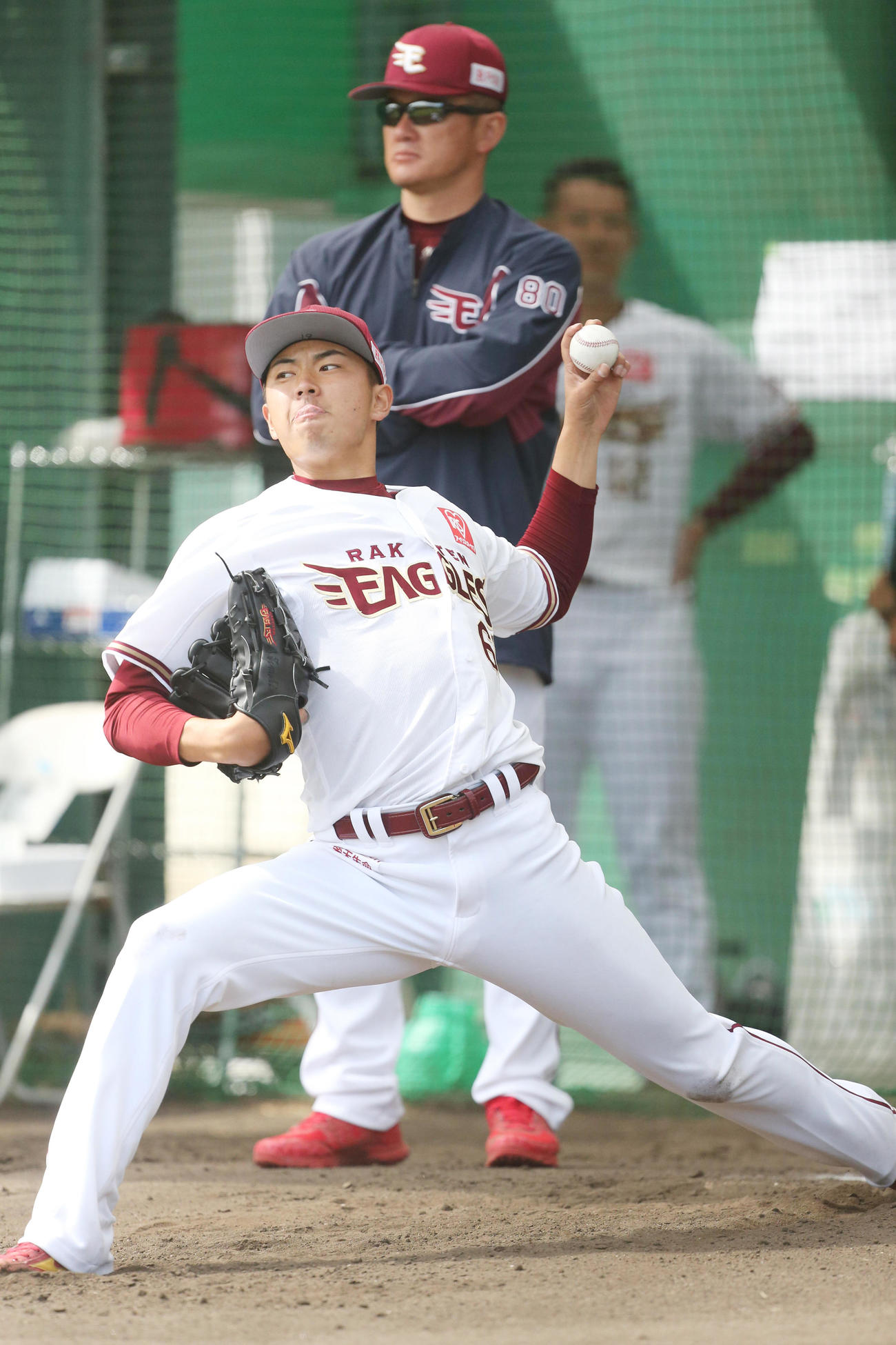 ブルペンで投球する楽天佐藤。後方は石井投手コーチ（2020年2月6日撮影）