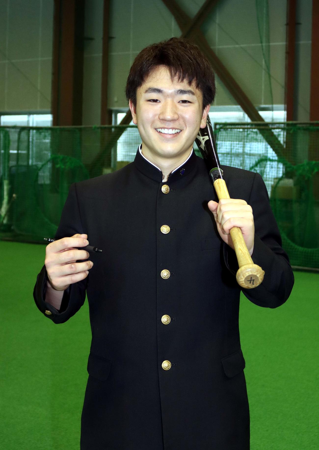 右手にペン、左手にバットを持ち笑顔の札幌第一・大坪内野手（撮影・永野高輔）