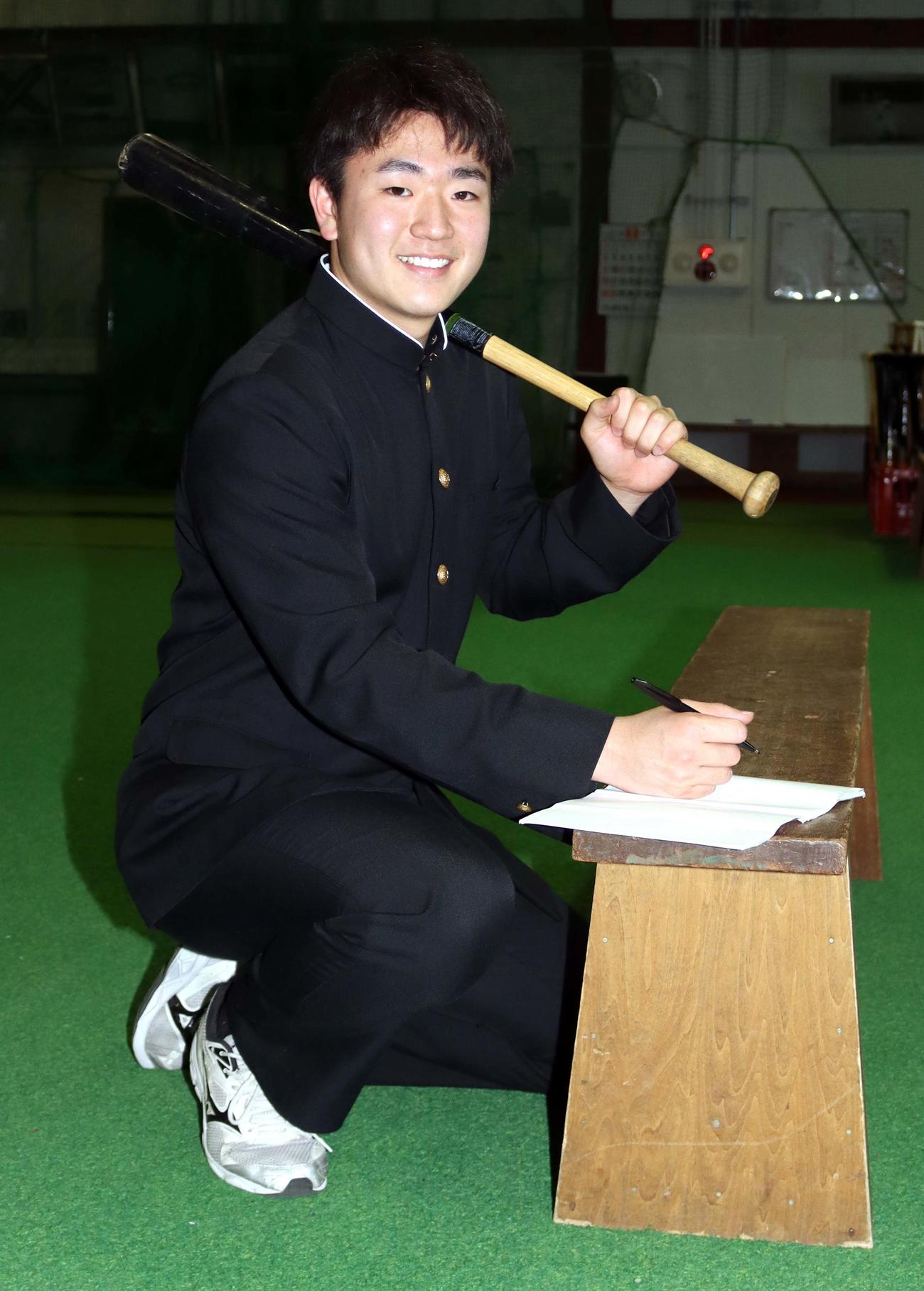 右手にペン、左手にバットを持ち笑顔の札幌第一・大坪内野手（撮影・永野高輔）