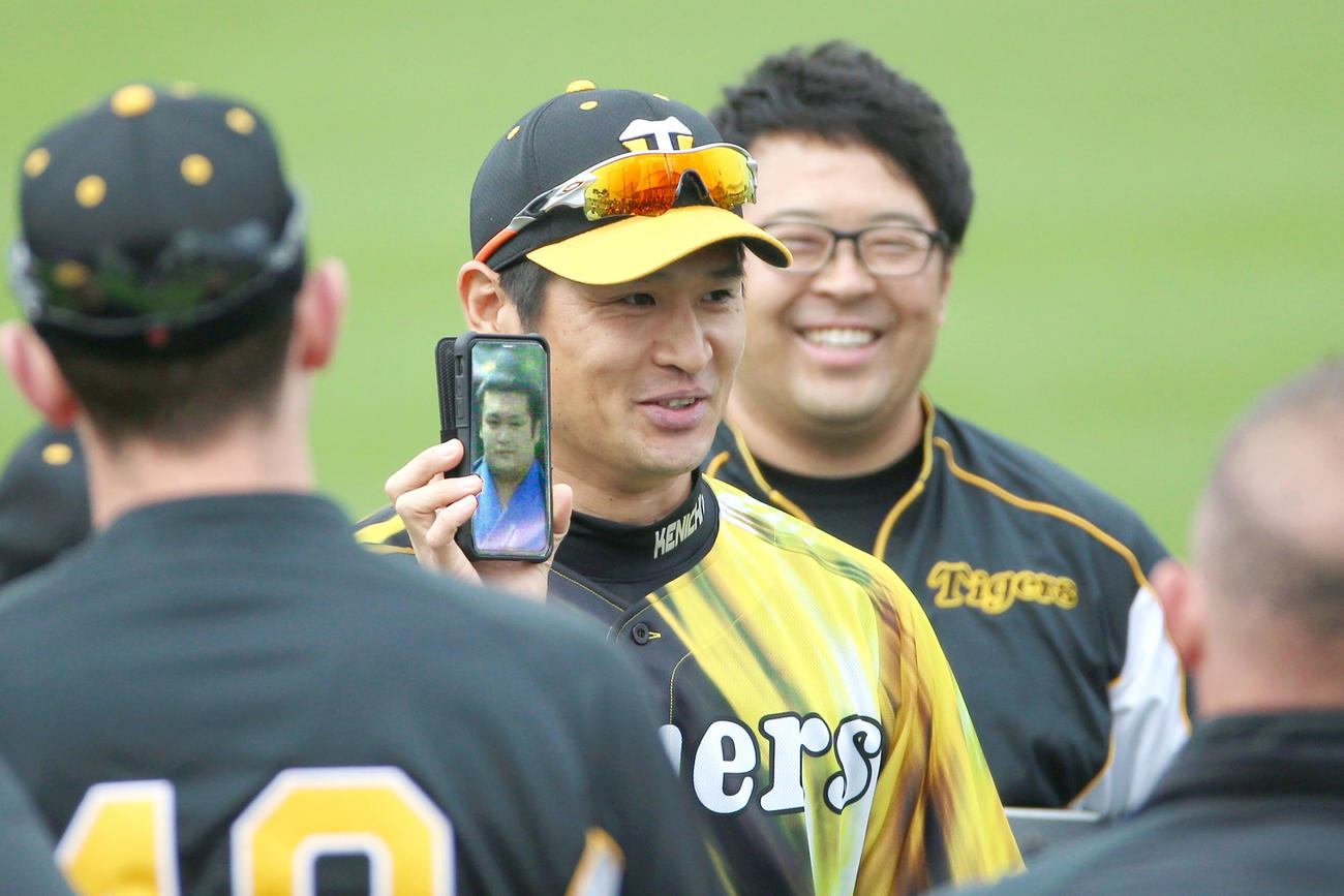 ワンデーキャプテン中田は千代の国と似ているとスマホ画面を見せる（撮影・上山淳一）