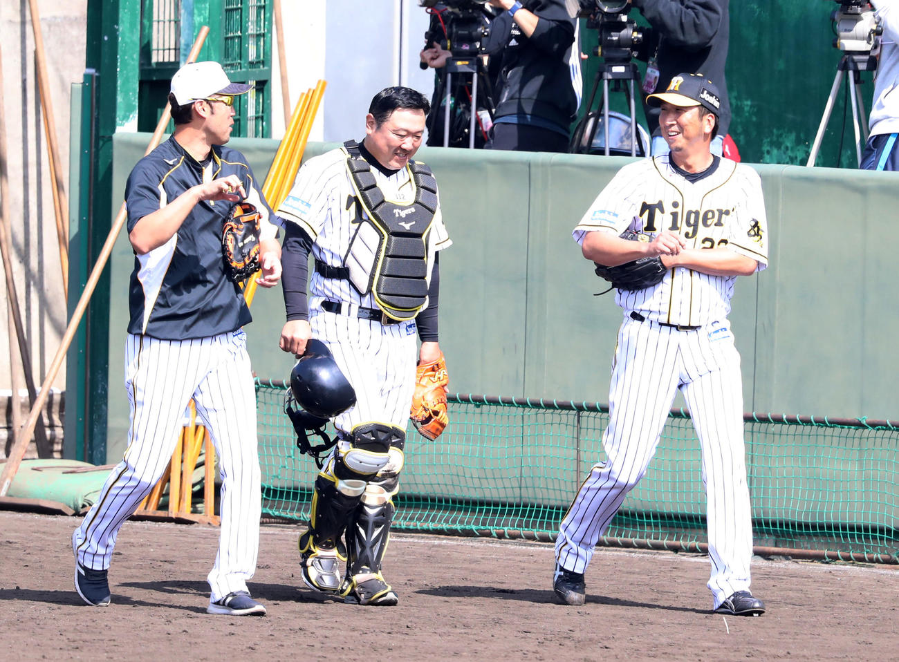 打撃投手の登板を終え金村コーチ（左端）、片山ブルペン捕手と談笑しながら引き揚げる藤川（撮影・加藤哉）