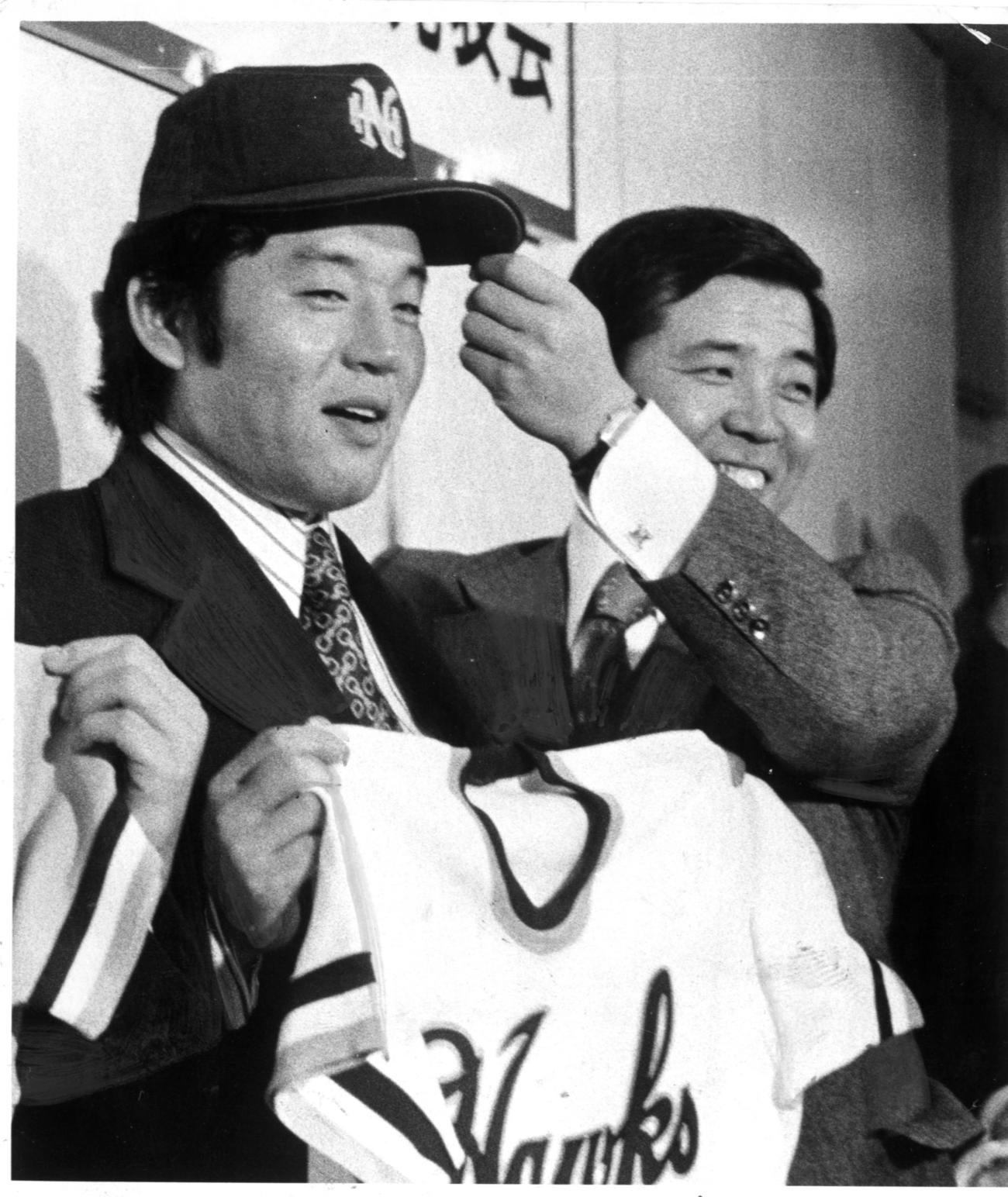 南海に移籍した江夏豊（左）は野村克也兼任監督から帽子をかぶせられる（1976年1月撮影）