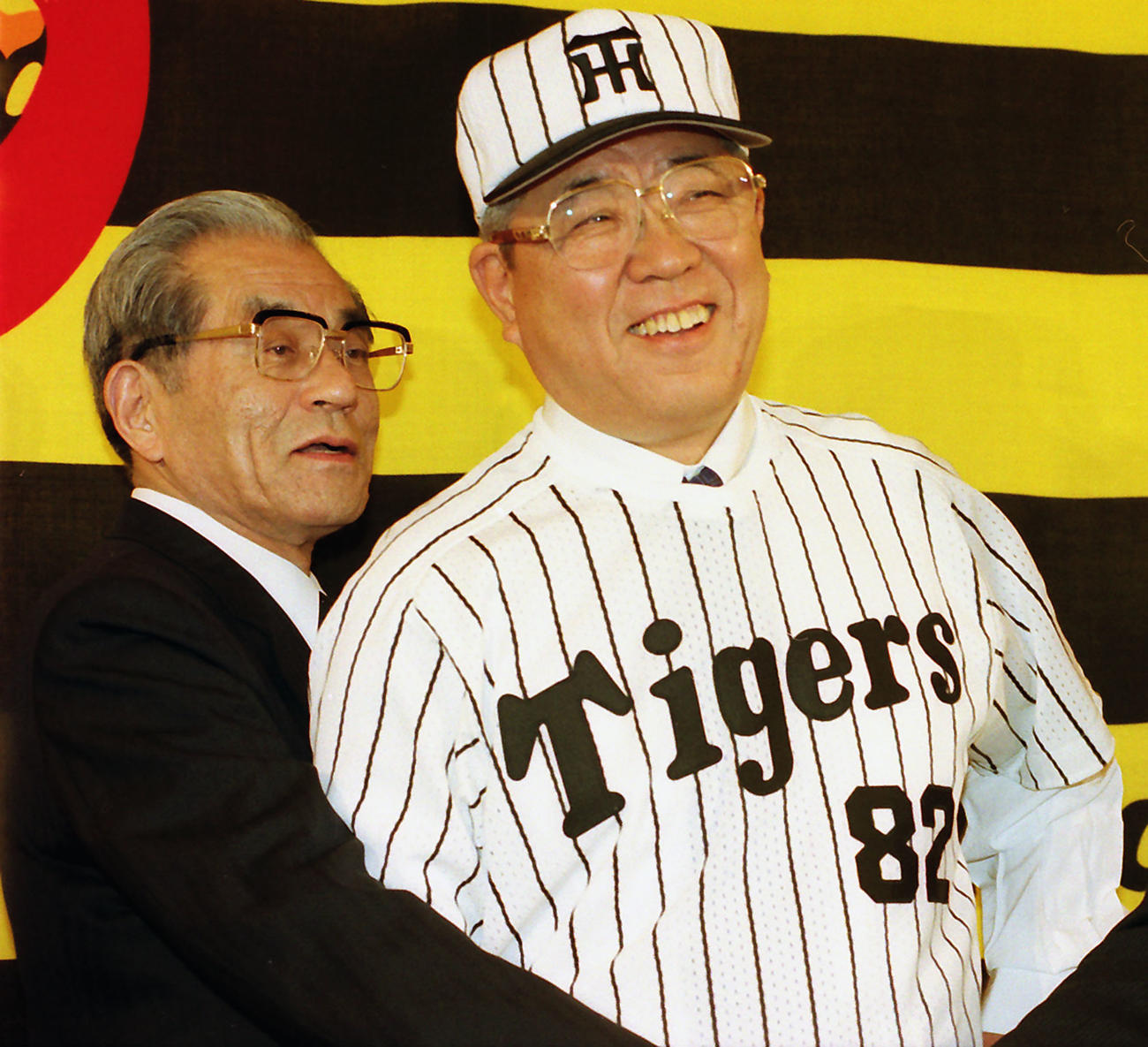 入団会見でタイガースのユニホームに袖を通し、笑顔を見せる野村克也監督。左は久万オーナー（1998年10月28日撮影）
