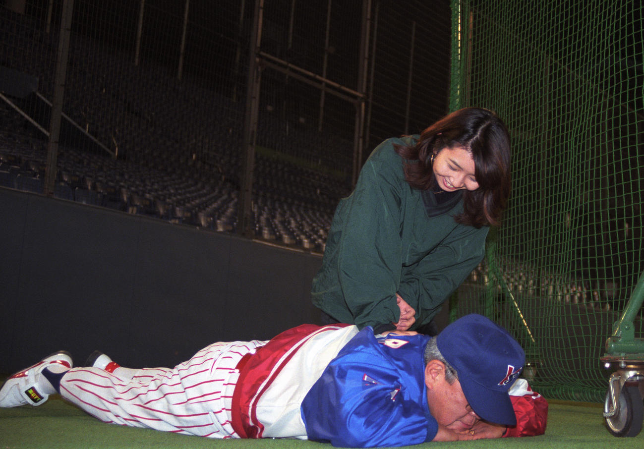 練習の合間にテレビ局の女性リポーターに腰をもんでもらうヤクルト野村克也監督　＝1997年10月14日　