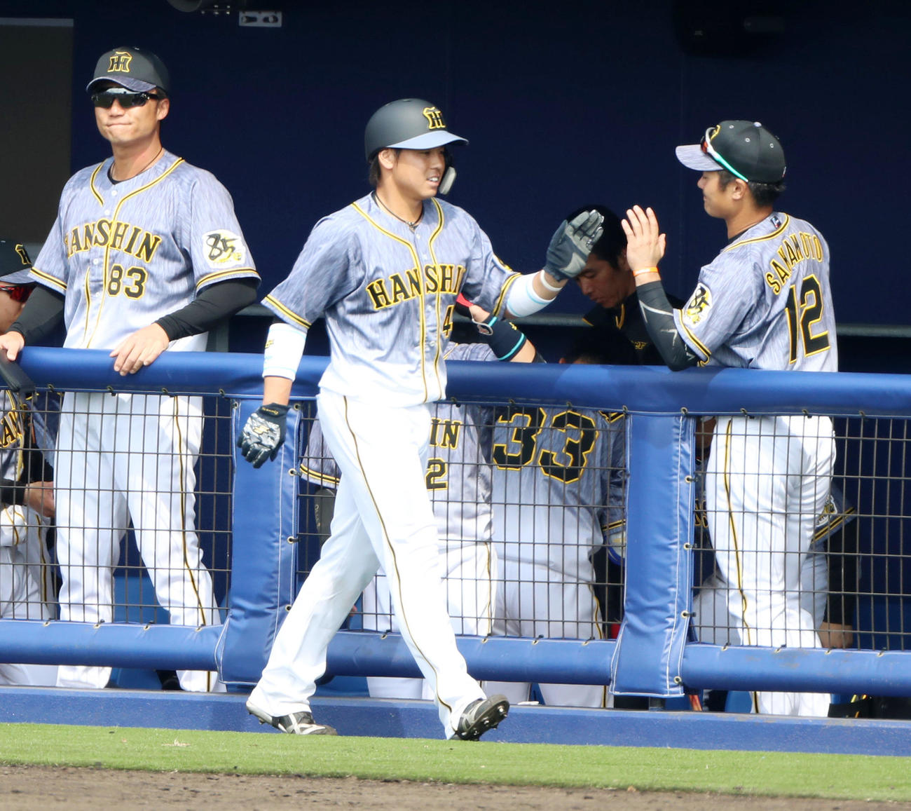 日本ハム対阪神　2回表阪神1死一、二塁、梅野は中前適時打放ち、攻守交代でベンチに戻るとナインからハイタッチで出迎えを受ける（撮影・加藤哉）