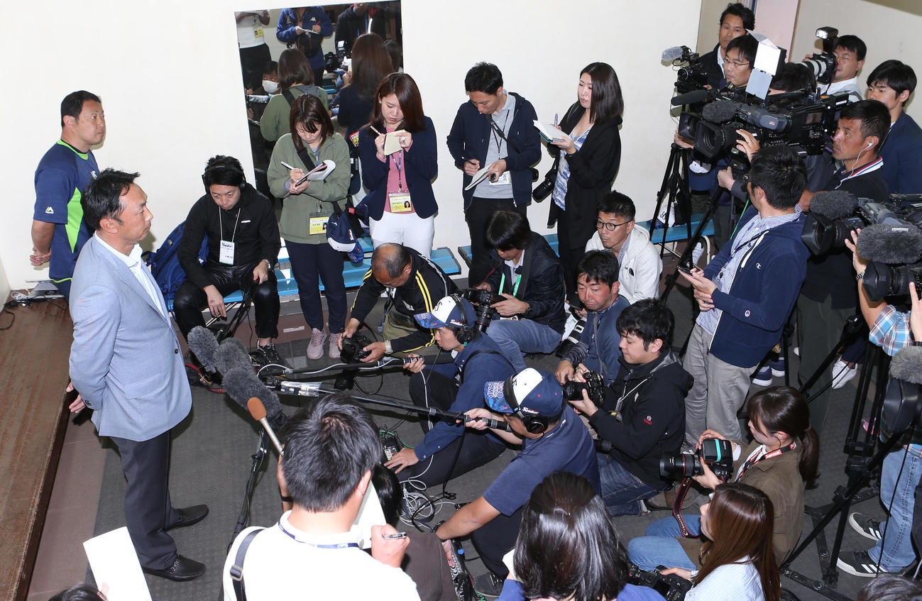 多くの報道陣の前で、亡くなった野村氏の話をする宮本氏（撮影・狩俣裕三）