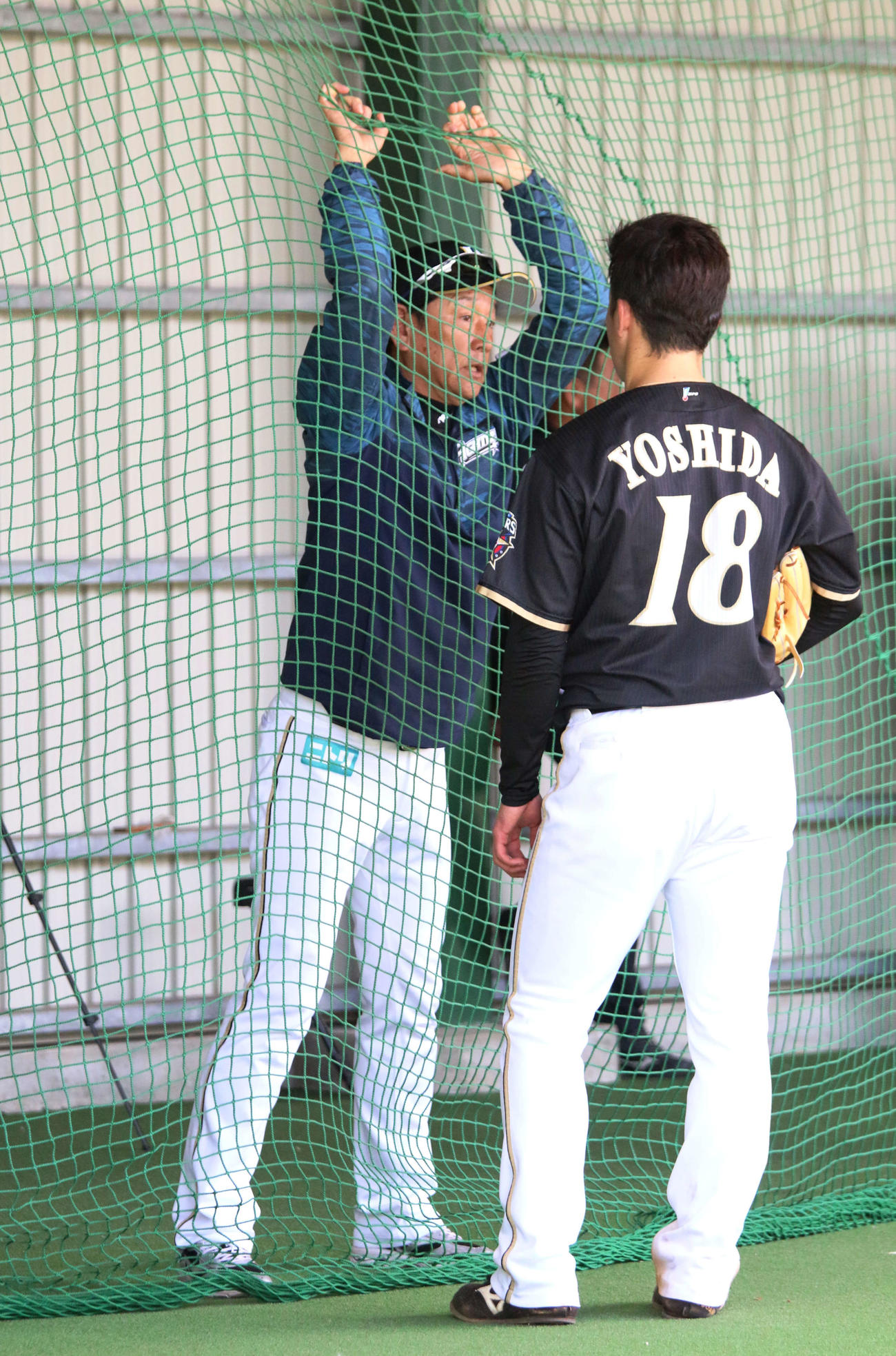 国頭キャンプでブルペン入りした日本ハム吉田輝と話をする栗山監督（左）（撮影・木下大輔）