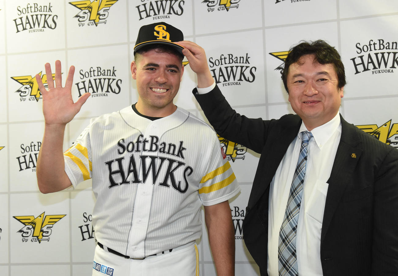 ソフトバンク春季キャンプ　入団会見を終え三笠杉彦取締役GMから帽子をかぶせてもらう新外国人のマット・ムーア（撮影・今浪浩三）