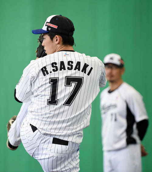 ブルペンで投球するロッテ佐々木朗(左)。右は吉井コーチ(撮影・横山健太)