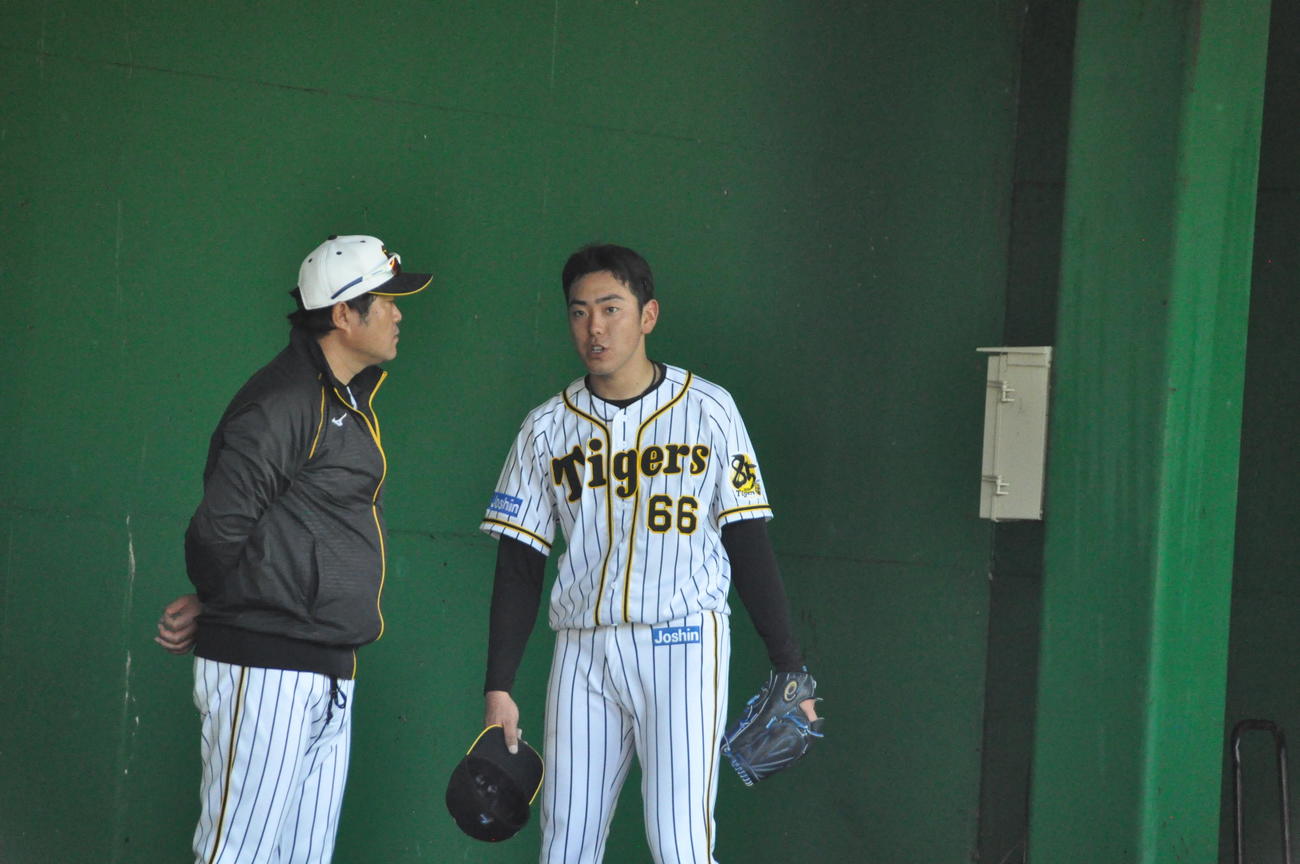 阪神ドラフト6位小川一平投手（22＝東海大九州、右）はブルペン投球後安藤投手コーチと話をする