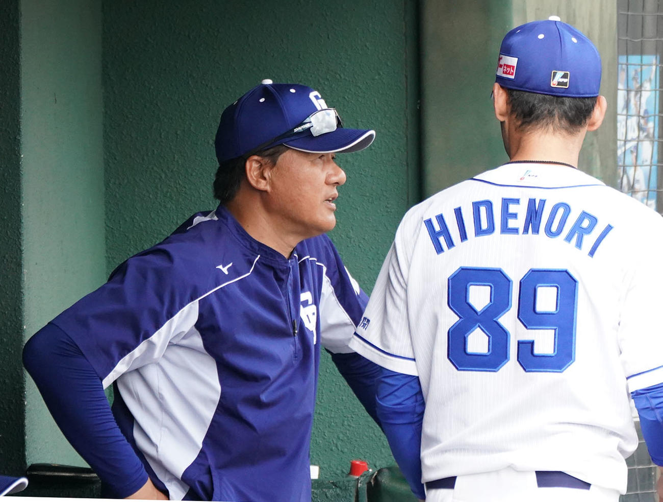 中日ドラゴンズ春季沖縄キャンプ　練習試合・中日対DeNA　7回裏中日攻撃終了、ベンチで英智外野守備走塁コーチと話す与田剛監督（撮影・森本幸一）