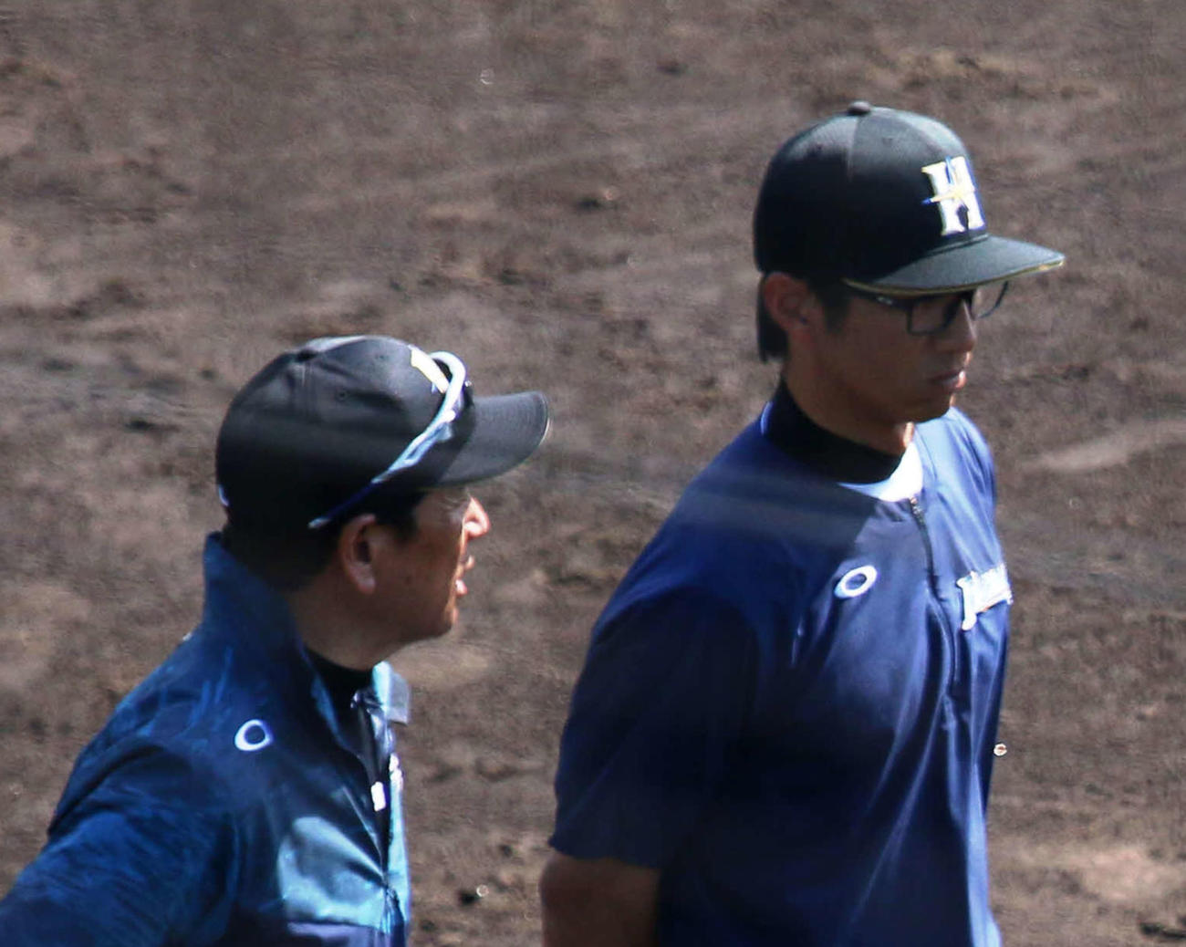 12日、2軍の沖縄・国頭キャンプを視察に来ていた日本ハム栗山監督（左）と倒れる直前まで並んで話していた城石2軍内野守備コーチ