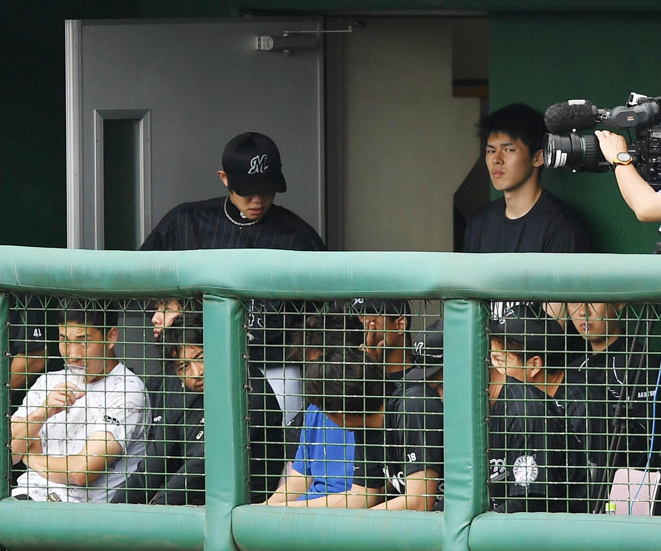 練習試合　広島対ロッテ　ベンチ横から試合を見学するロッテ佐々木朗（右）（撮影・横山健太）