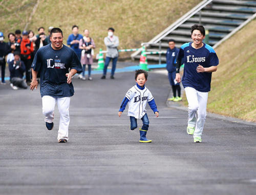西武の山川(左)と源田と一緒に長靴で懸命に坂道ダッシュする男の子。無事に頂上までゴール…(撮影・足立雅史)