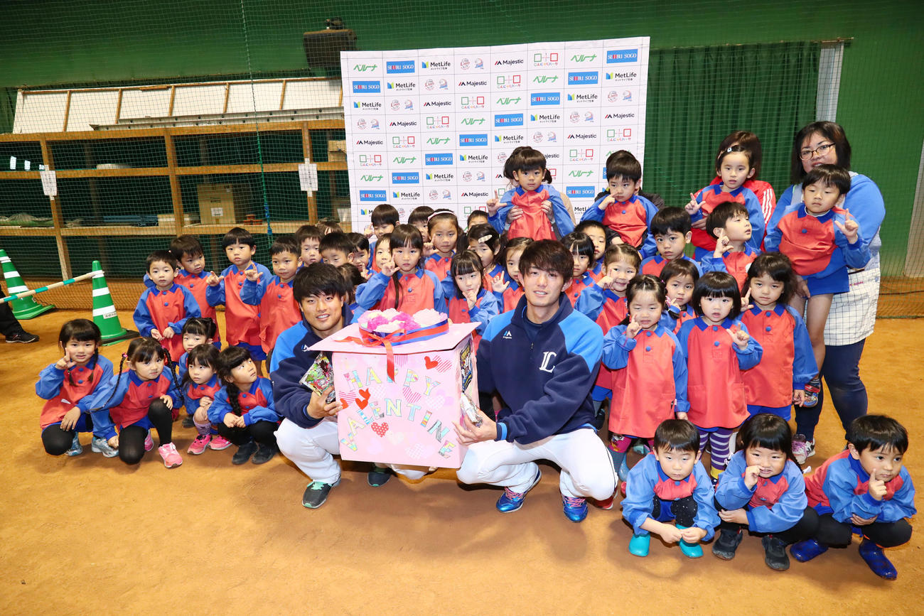 日南市南郷町・立正幼稚園の園児からチョコレートを受け取り笑顔を見せる西武の松本航（左）と今井（撮影・足立雅史）