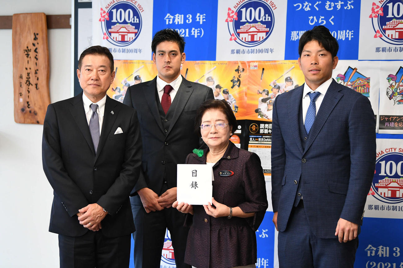 城間那覇市長（中央）へ首里城再建に向けた義援金を手渡し、記念撮影に応じる、左から巨人原監督、与那原、1人空けて大城（撮影・加藤諒）