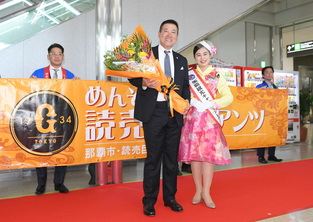 那覇空港に到着し、那覇観光キャンペーンレディーの城間愛さん（右）から花束を受け取る巨人原辰徳監督（撮影・加藤諒）
