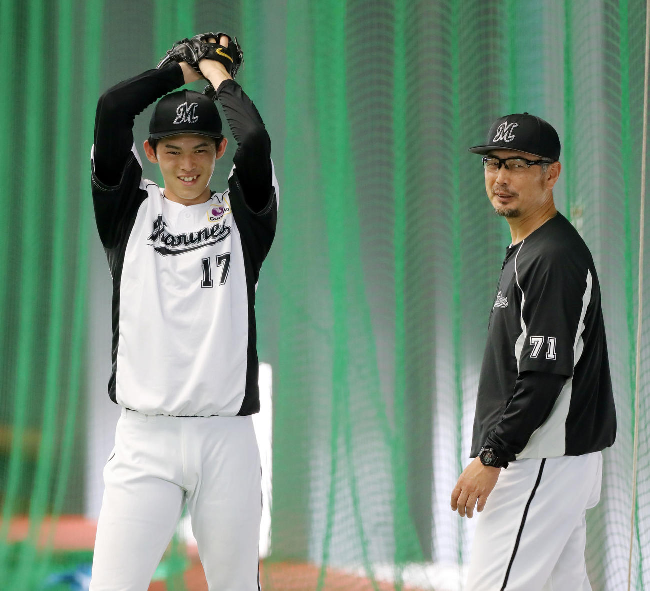ロッテ対広島　試合前、室内練習場でキャッチボールするロッテ佐々木朗（左）と笑顔で言葉を交わす吉井投手コーチ（撮影・垰建太）