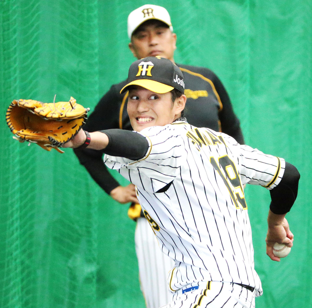 ブルペンで投球練習をする藤浪、後方は山本昌臨時コーチ（撮影・上山淳一）