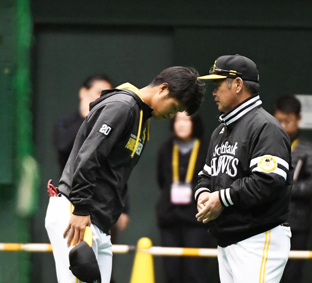 練習前、工藤監督（右）に右ひじ違和感を伝え頭を下げる甲斐野（撮影・今浪浩三）