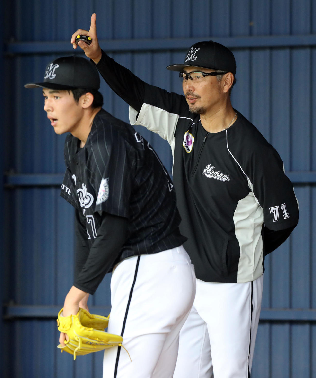 中日対ロッテ　試合前、ブルペンで投げ込むロッテ佐々木朗（手前）の後方で捕手にラスト1球をジェスチャーする吉井投手コーチ（撮影・垰建太）