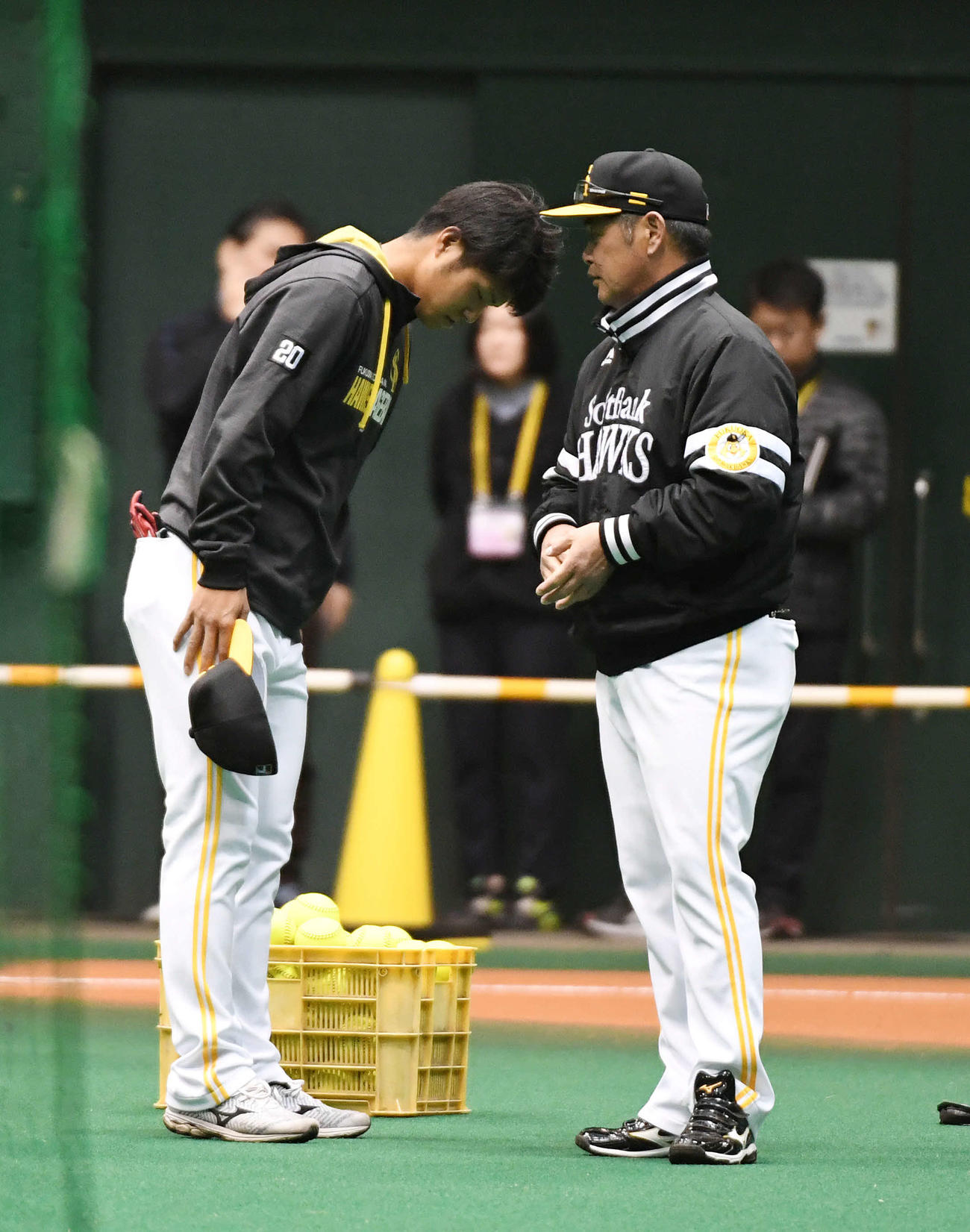 練習前、工藤監督（右）に右ひじ違和感を伝え頭を下げる甲斐野（撮影・今浪浩三）