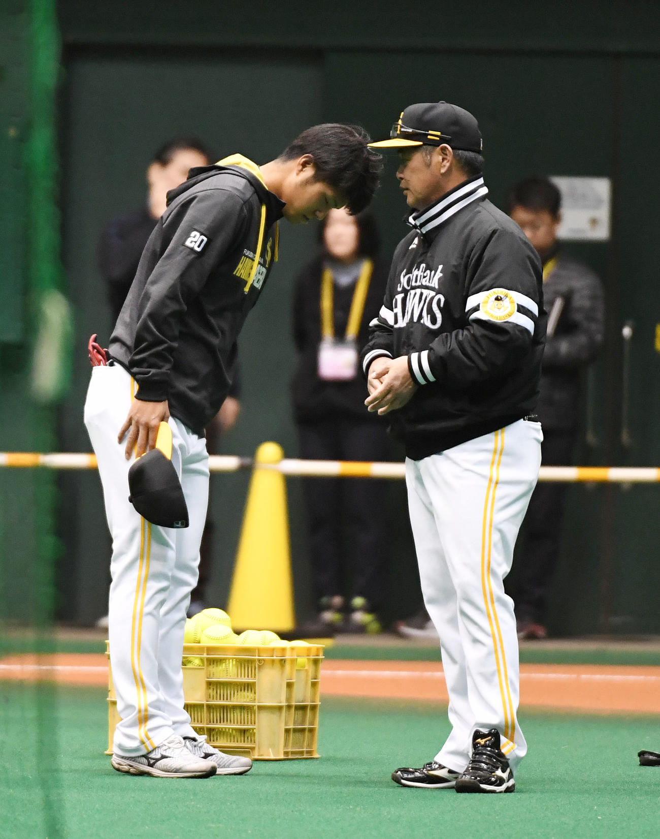 練習前、工藤監督（右）に右ひじ違和感を伝え頭を下げる甲斐野（撮影・今浪浩三）
