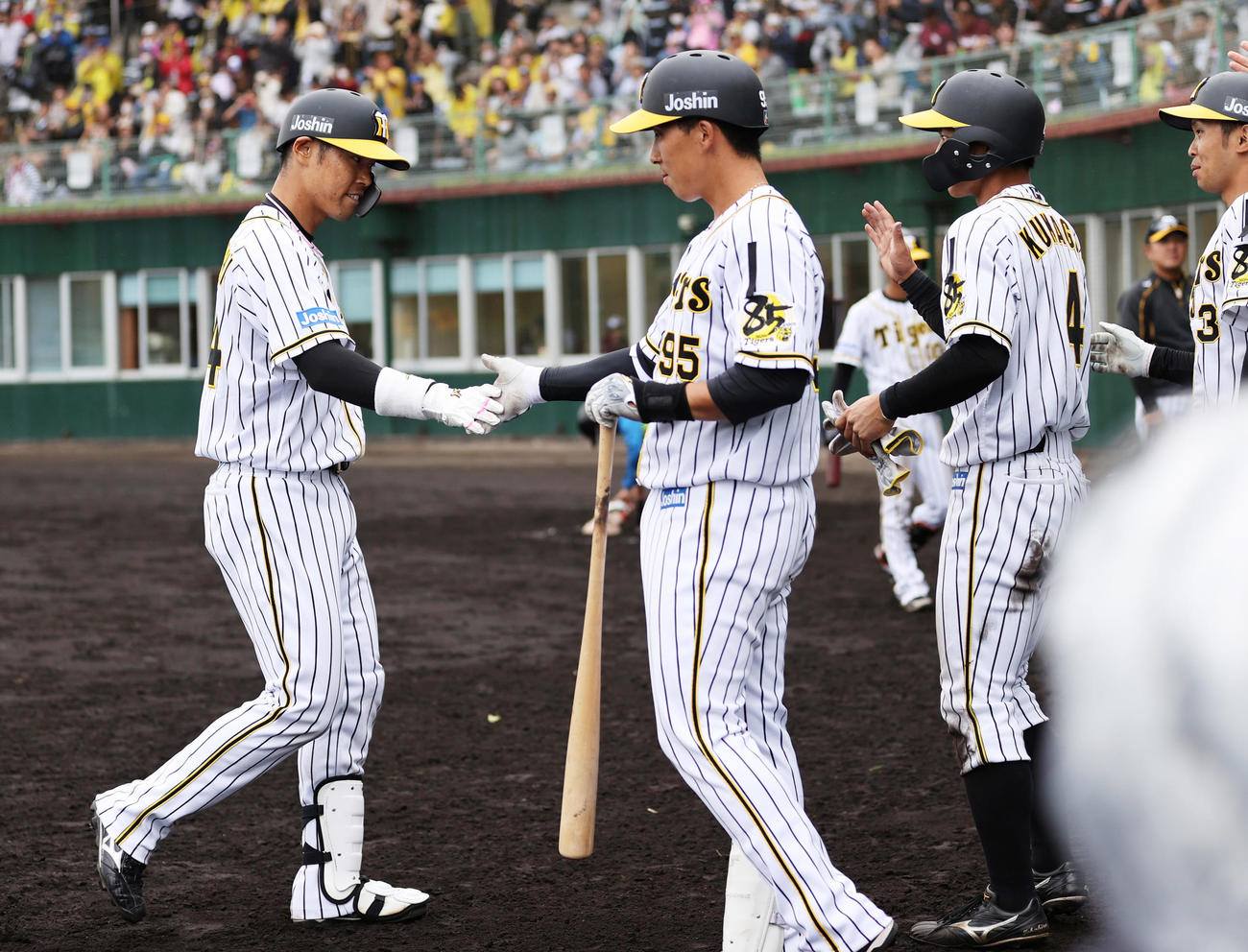 練習試合阪神対楽天　9回裏阪神1死二塁、左中間をやぶるサヨナラ打を放ちベンチでタッチを交わす原口（左）（撮影・清水貴仁）