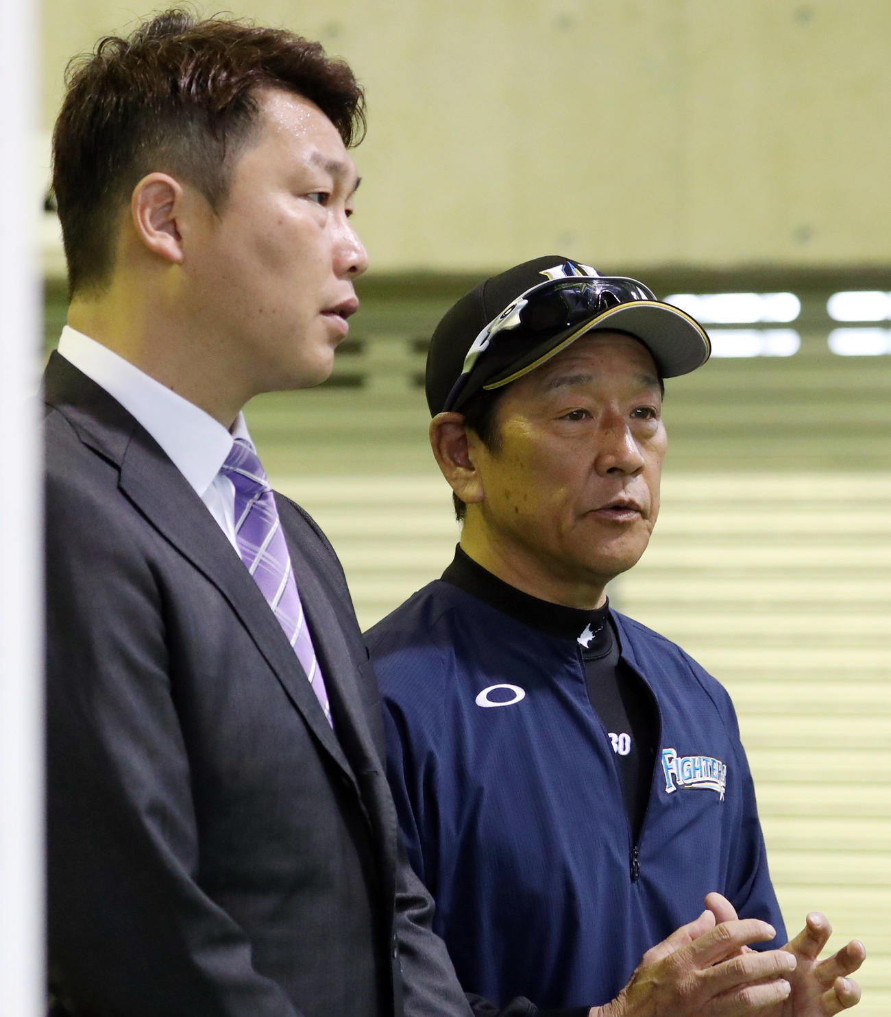 ヤクルト室内練習場で談笑する新井氏（左）と栗山監督（撮影・狩俣裕三）
