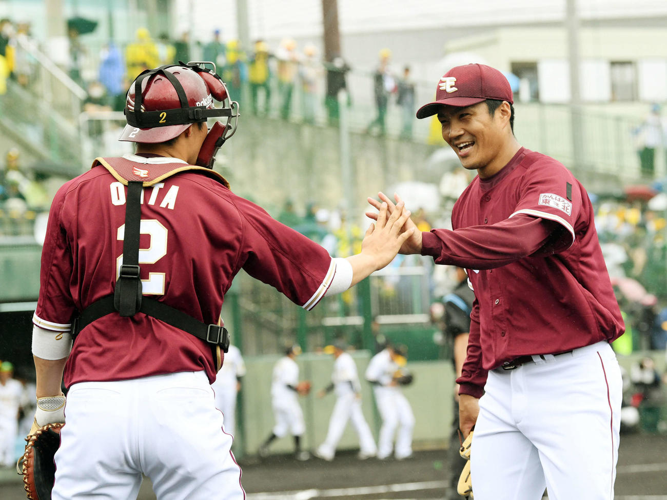 阪神対楽天　1回を投げ終え笑顔で楽天太田（左）とタッチを交わす則本昂（撮影・滝沢徹郎）