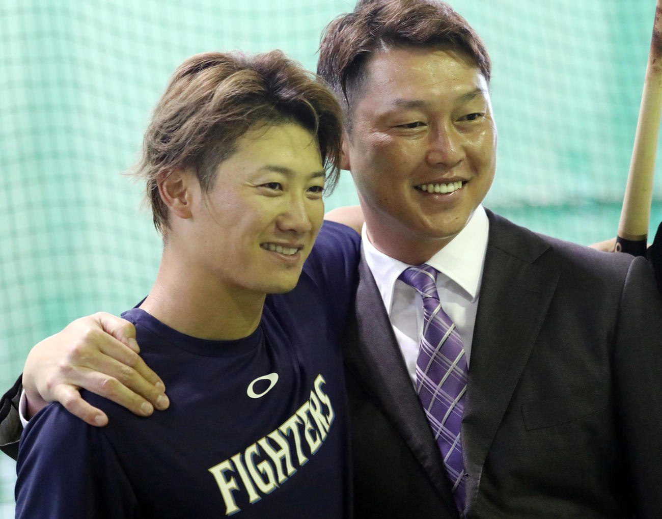 ヤクルト室内練習場で記念撮影する西川（左）と新井氏（撮影・狩俣裕三）
