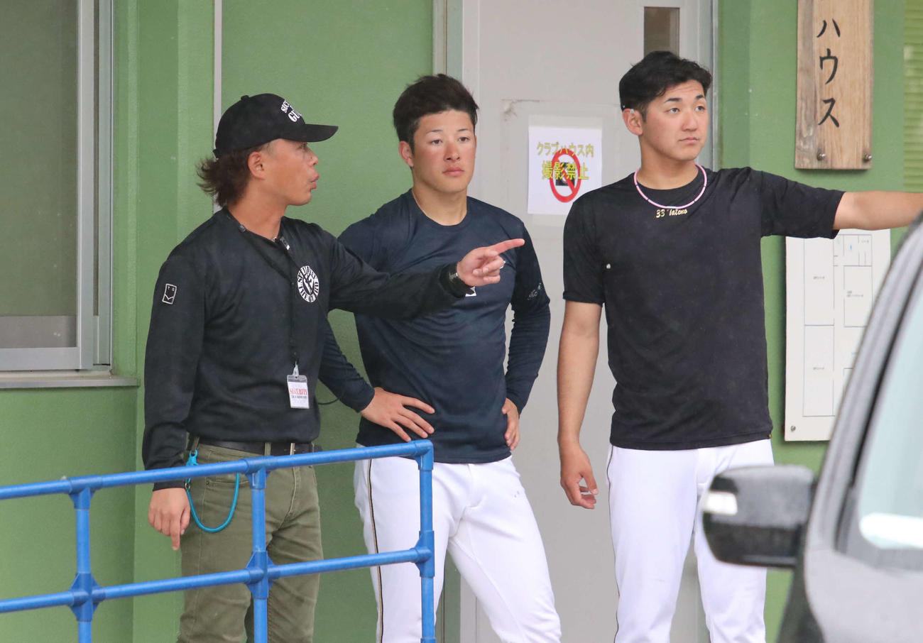 室内練習場へと移動するため、クラブハウス前で待機する日本ハム吉田輝（中央）。右は立野（撮影・山崎純一）