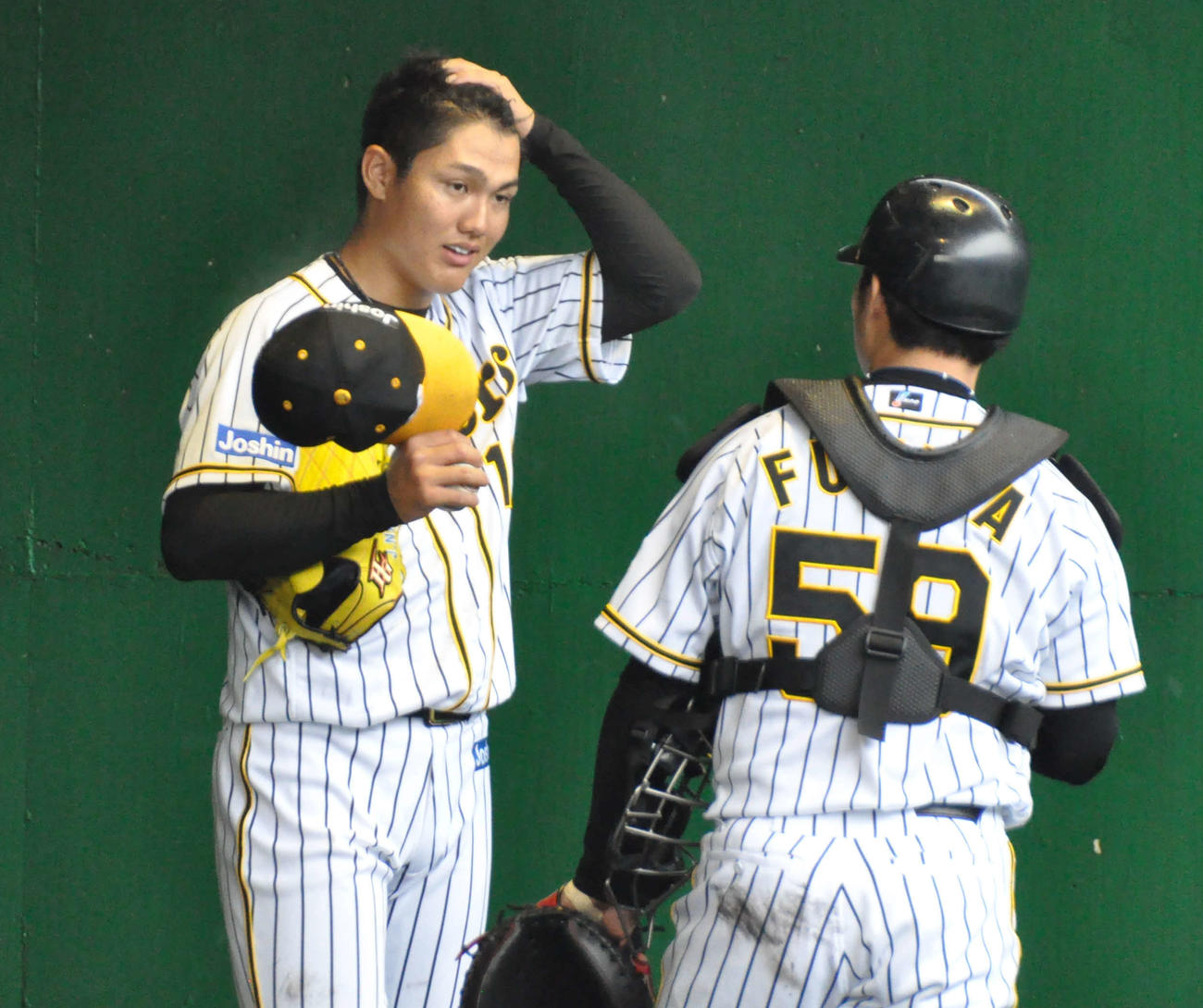 初めてブルペンでバッテリーを組み、投球後話をする西純（左）と藤田（撮影・石橋隆雄）